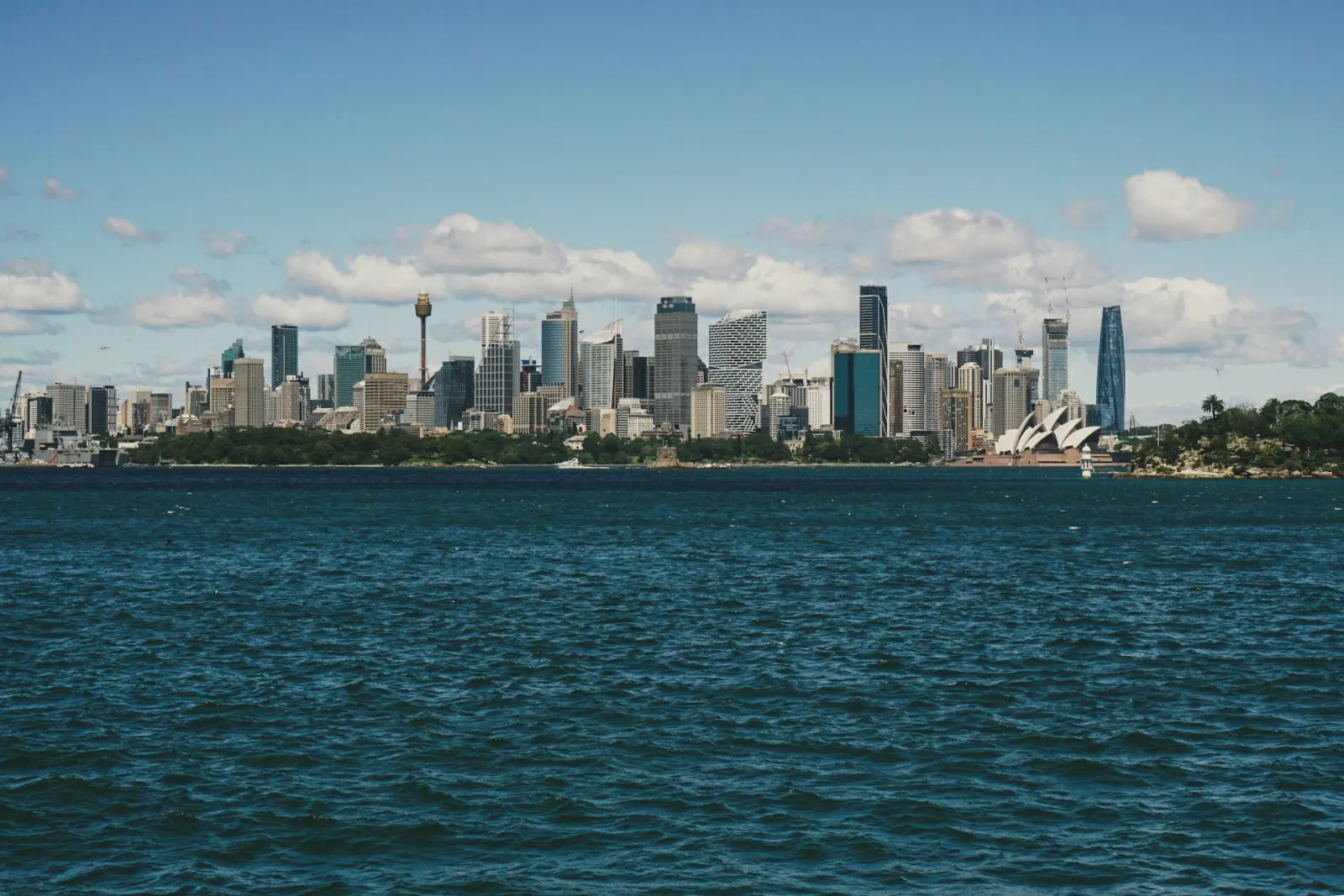 The Sydney city skyline and Opera House seen across the harbour on a sunny day, representing Australian brands competing under a new wave of customer-facing regulation.