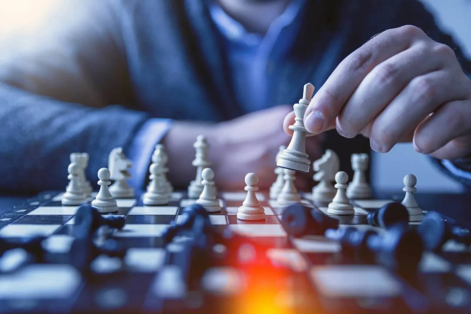 Depth of field photograph of a person playing chess, representing competitive strategy and market positioning.