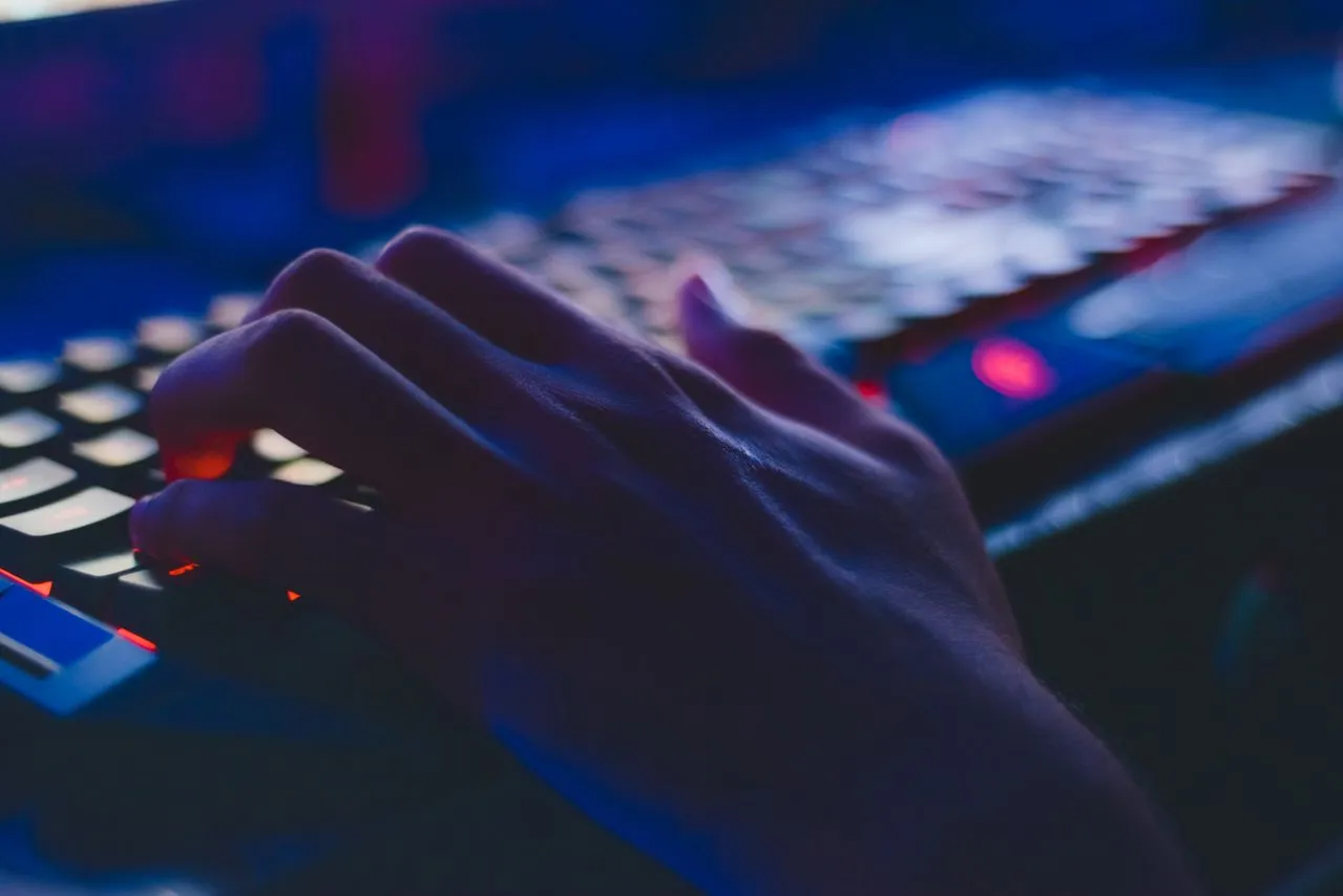 Overhead view of a hand completing an online checkout or booking form on a laptop, representing the moment where conversion is won or lost in the user journey.